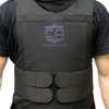 Front view of man wearing a Caliber Armor covert hybrid concealable carrier in black, faint blue "CA Caliber Armor" logo visible in the center of the chest, two cummerbund straps per side that velcro to adjust fit