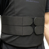 Close up view of man wearing a Caliber Armor covert hybrid concealable carrier in black, showing the two elastic cummerbund straps per side that velcro to adjust fit