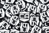 a pile of pvc patch with velcro backing that is the Caliber Armor logo in white with the background being black